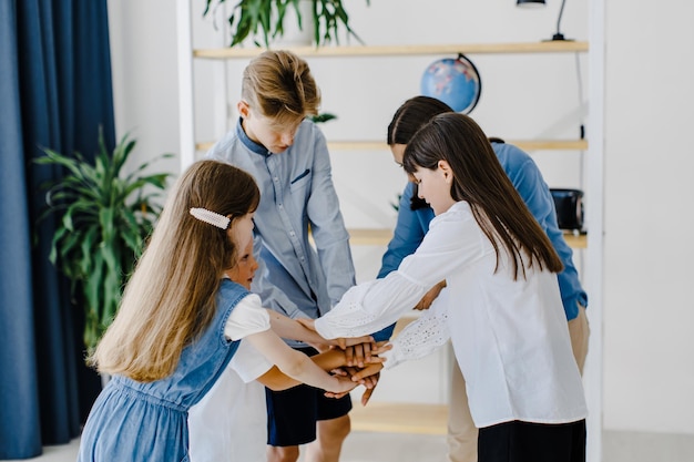 Vue latérale Femme avec ses enfants étudiants se tenant la main pour réussir