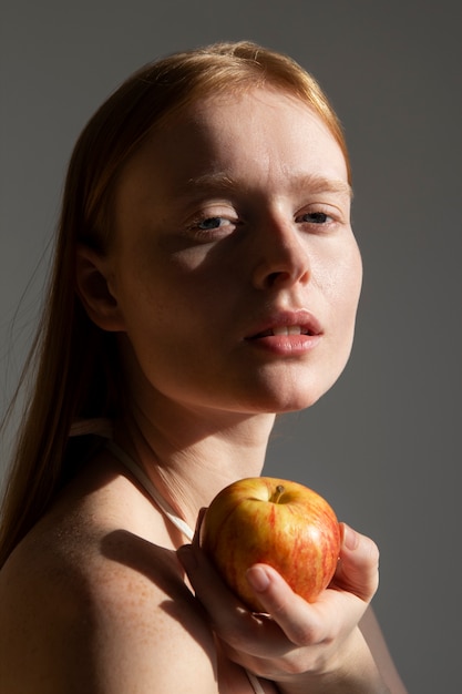 Photo vue latérale femme tenant une pomme fraîche