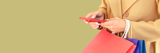 Photo vue latérale d'une femme tenant un smartphone et des sacs à provisions pour cyber lundi avec espace copie