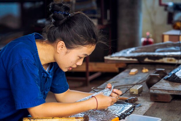 Photo vue latérale d'une femme travaillant à l'atelier