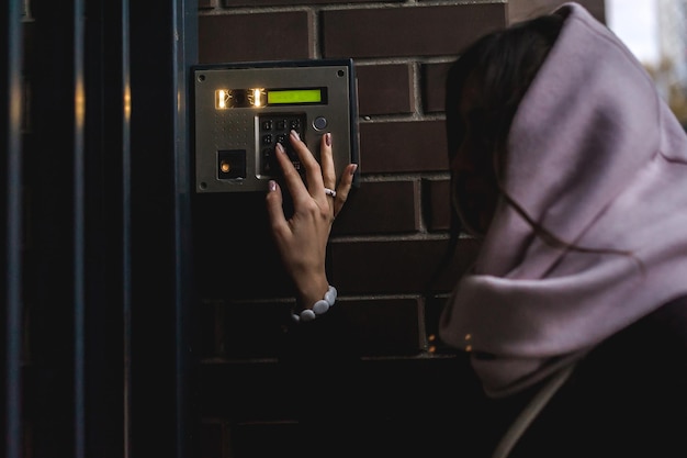 Photo vue latérale d'une femme utilisant le système de sécurité à l'entrée de la maison