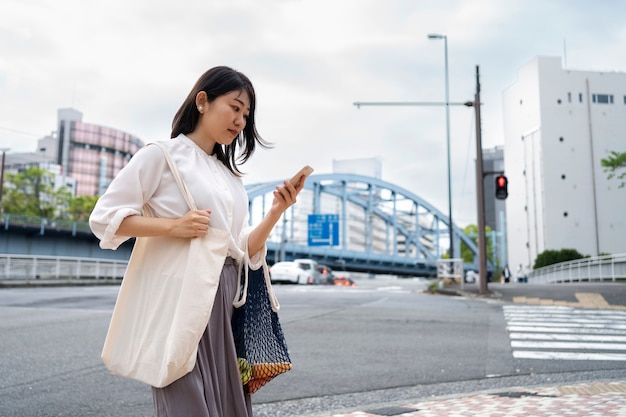 Photo vue latérale femme vérifiant son téléphone