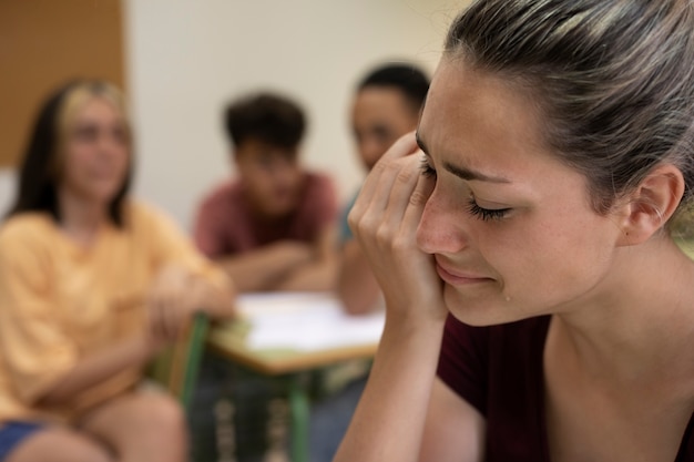 Photo vue latérale fille pleurant à l'école