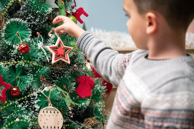 Vue latérale d'un garçon décorant un sapin de Noël