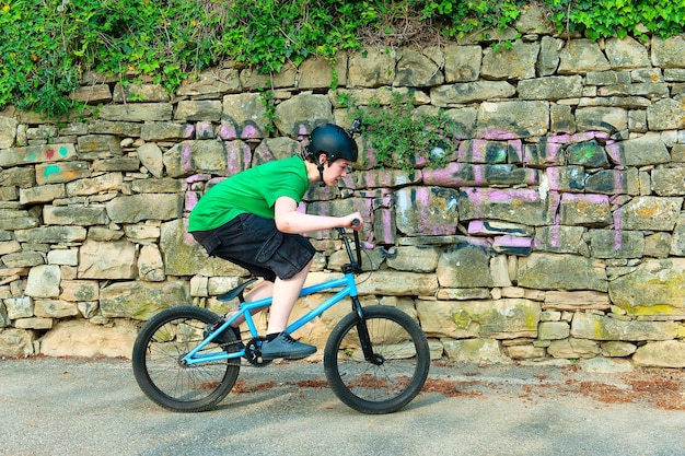 Vue latérale d'un garçon à vélo contre le mur