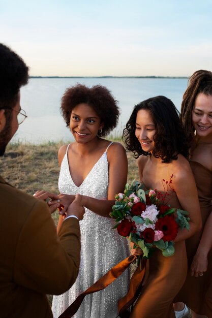 Photo vue latérale des gens célébrant un mariage dans la nature