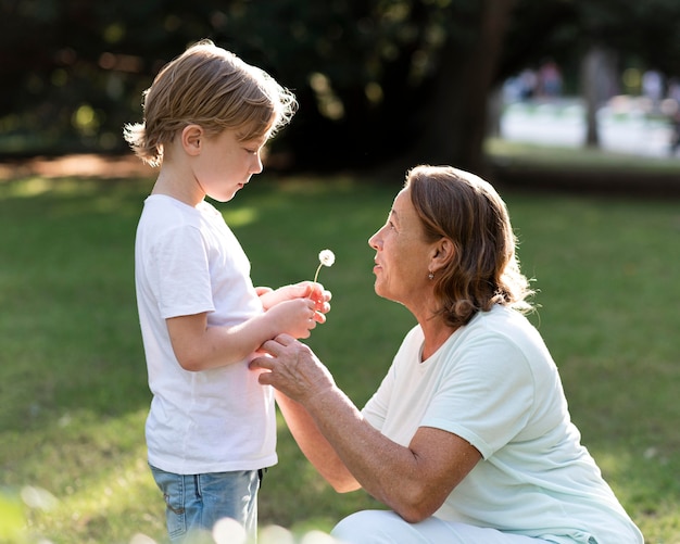 Photo vue latérale grand-mère et enfant avec fleur