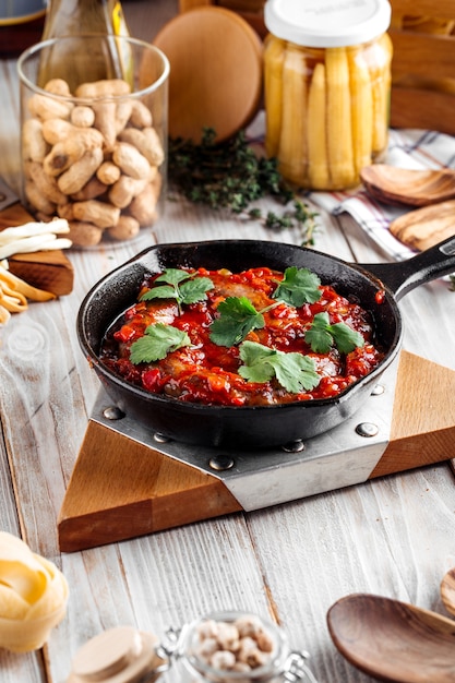 Vue latérale sur une grande saucisse cuite à la sauce tomate dans une casserole castiron