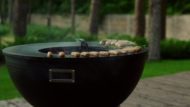 Vue latérale sur le gril du bol à l'extérieur Bâtonnets de viande grillés sur le gril pour la fête du barbecue