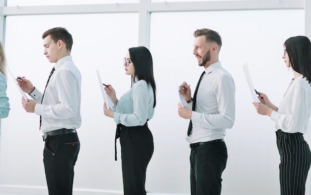 Vue latérale.groupe d'employés debout dans le hall du bureau. concept d'entreprise