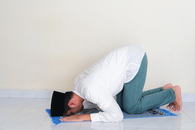 Photo vue latérale d'un homme asiatique musulman priant