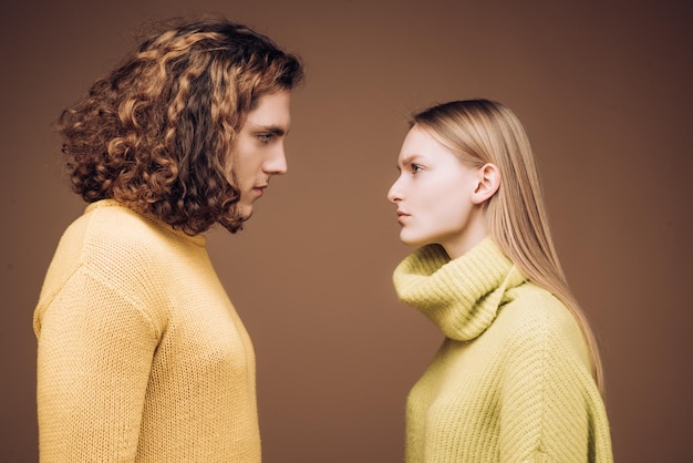 Vue latérale homme bouclé et femme blonde face à face les yeux ouverts concept de confrontation dans la fam