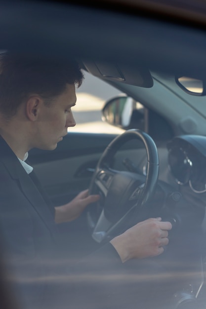 Photo vue latérale homme conduisant une voiture