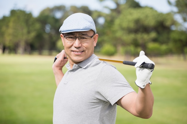Vue latérale d'un homme confiant tenant un club de golf
