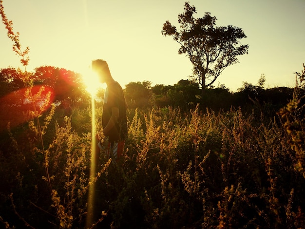 Photo vue latérale d'un homme debout sur un champ contre le ciel pendant une journée ensoleillée