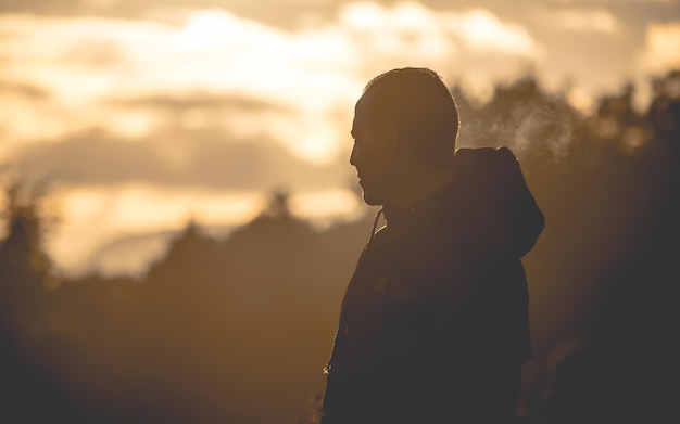 Photo vue latérale d'un homme debout contre le ciel au coucher du soleil