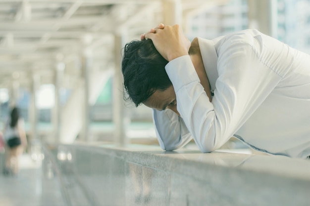Vue latérale d'un homme déprimé sur la balustrade