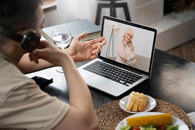 Photo vue latérale homme faisant un appel vidéo