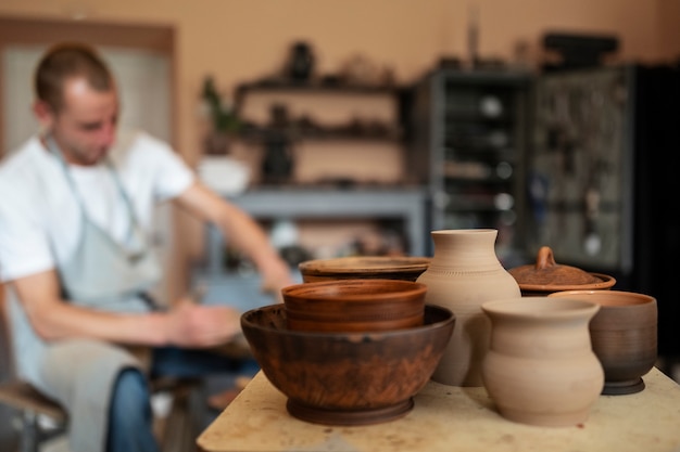 Vue latérale homme flou faisant de la poterie