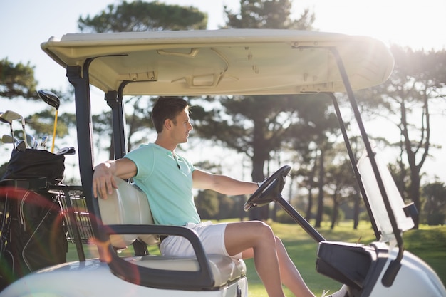 Vue latérale d'un homme intelligent assis dans un buggy de golf