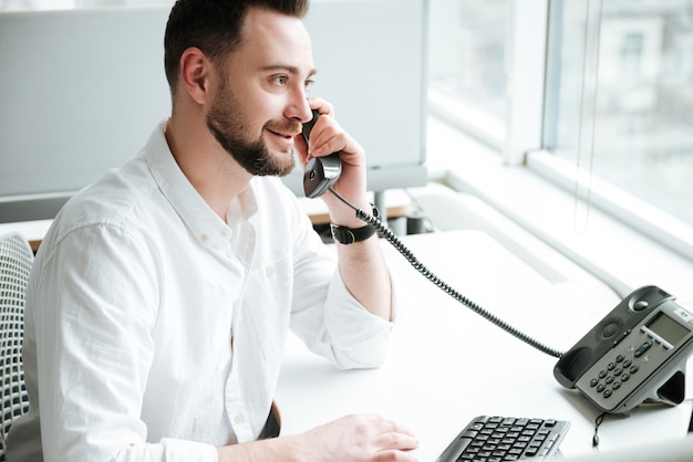 Vue latérale d'un homme parlant au téléphone