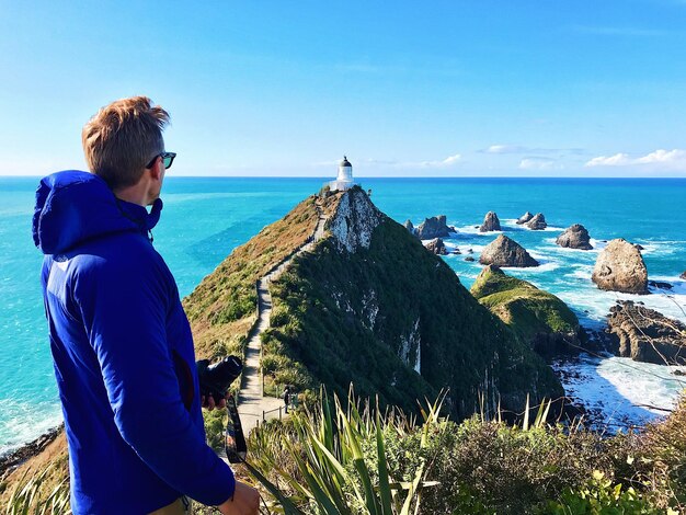 Photo vue latérale d'un homme regardant la mer contre le ciel