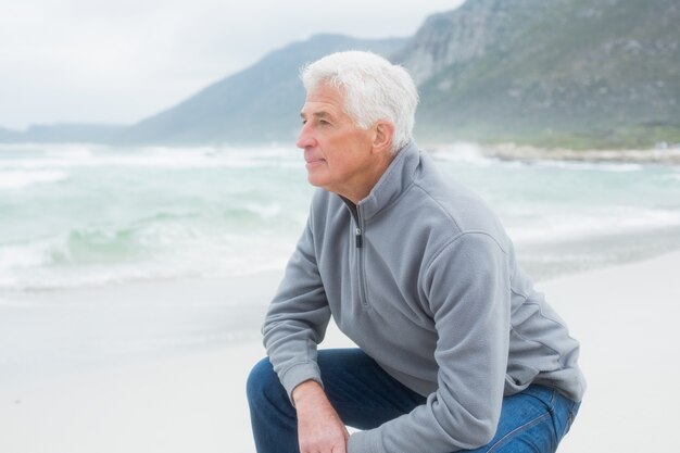 Vue latérale d&#39;un homme senior détente sur la plage