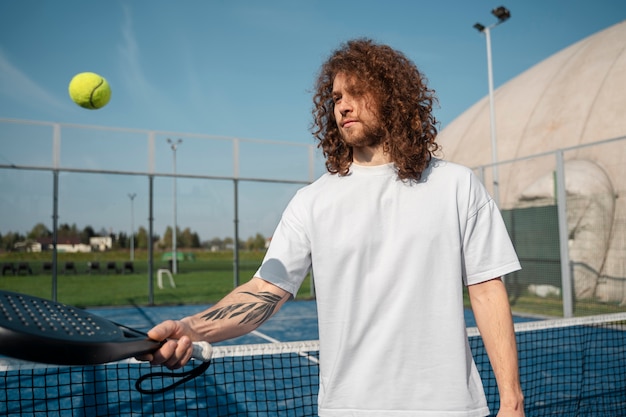 Vue latérale homme tenant une raquette de tennis
