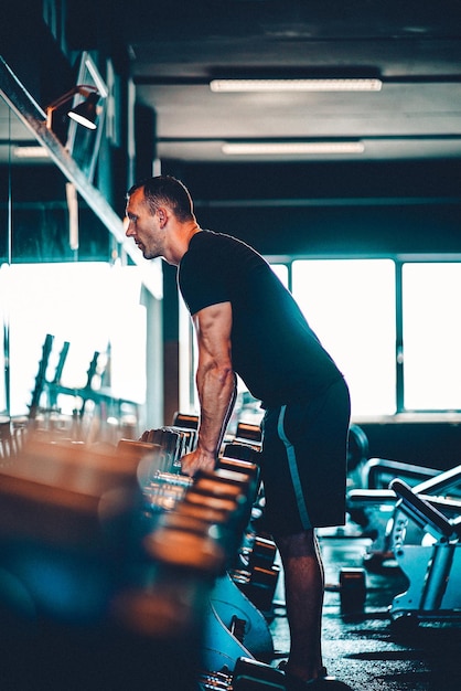 Vue latérale d'un homme en train de faire de l'exercice au gymnase