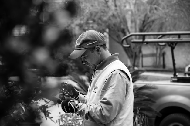 Photo vue latérale de l'homme utilisant une tablette numérique par des plantes