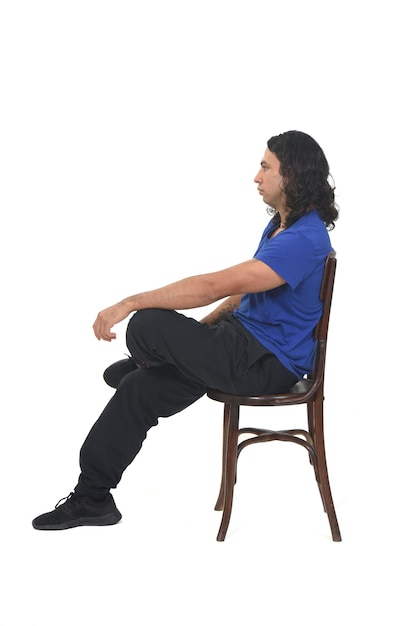 Vue latérale d'un homme avec des vêtements de sport assis sur une chaise sur fond blanc