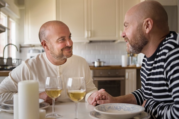 Photo vue latérale des hommes souriants à table