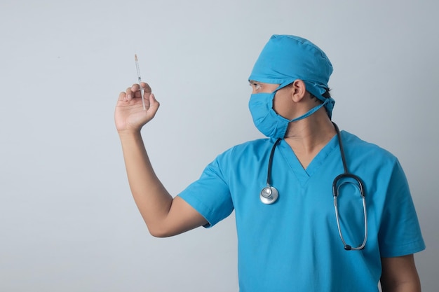Vue latérale infirmier asiatique tenant une seringue dans la main