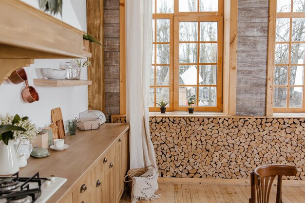 Vue latérale de l'intérieur de la cuisine de style scandinave dans des tons blancs avec cuisinière, évier et étagères. Luxe