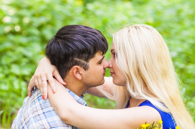 Photo vue latérale d'un jeune couple s'embrassant à l'extérieur