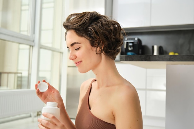 Vue latérale d'une jeune femme buvant du lait à la maison