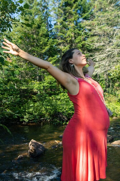 Photo vue latérale d'une jeune femme debout contre des arbres