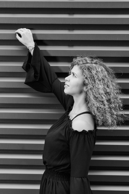 Photo vue latérale d'une jeune femme debout contre l'escalier