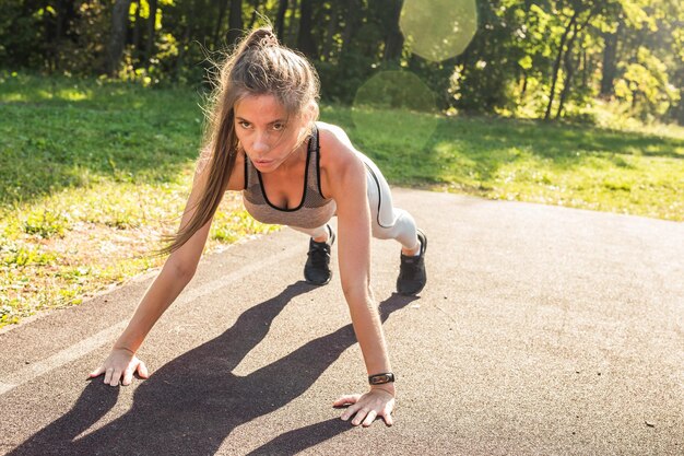 Vue latérale d'une jeune femme faisant de l'exercice sur le terrain