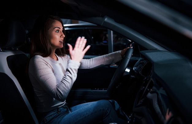 Vue latérale d'une jeune femme à l'intérieur d'une toute nouvelle automobile moderne.