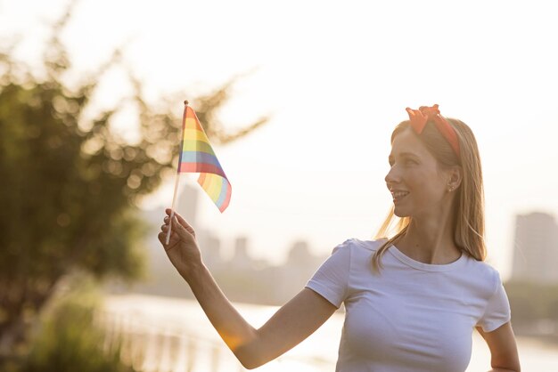 Photo vue latérale d'une jeune femme tenant un drapeau contre le ciel