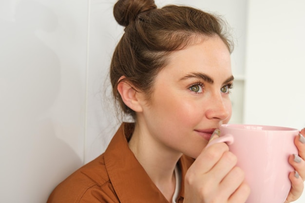 Vue latérale d'une jeune femme utilisant un téléphone portable à la maison