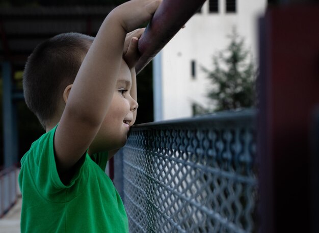 Photo vue latérale d'un jeune garçon qui regarde à travers