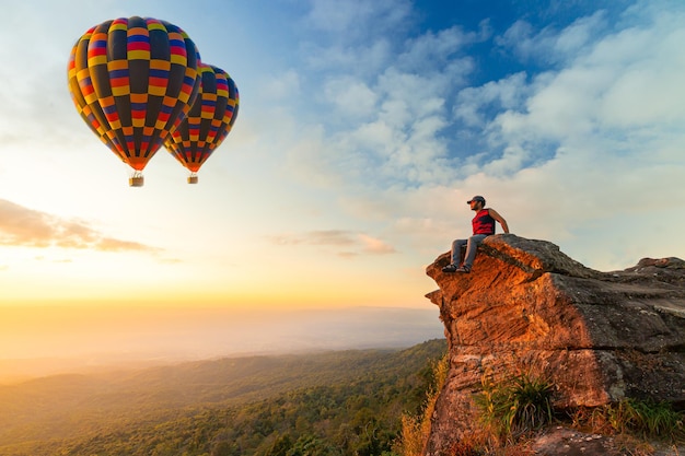 vue latérale d'un jeune homme assis pendant le festival de montgolfières