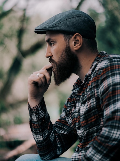 Vue latérale d'un jeune homme barbu qui détourne le regard