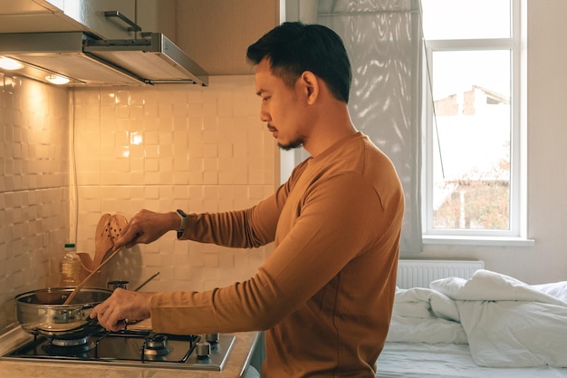 Vue latérale d'un jeune homme debout à la maison