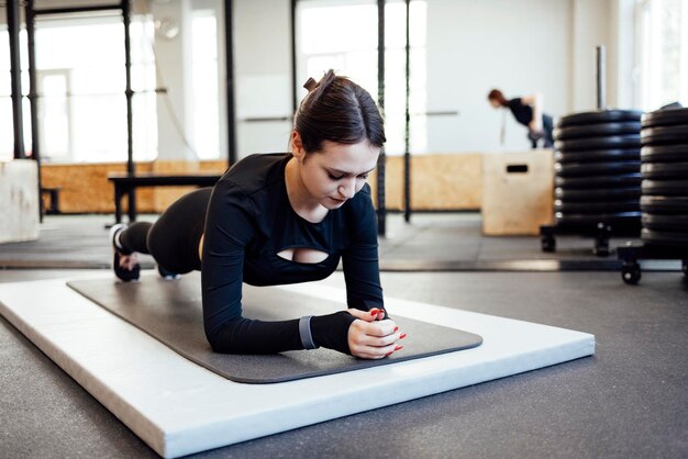 Photo vue latérale d'un jeune homme faisant de l'exercice au gymnase