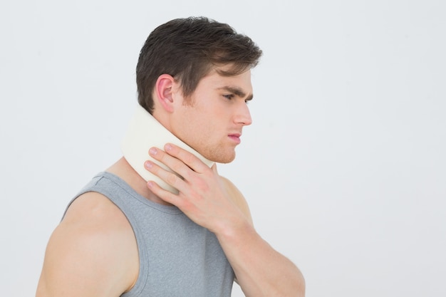 Vue latérale d&#39;un jeune homme portant un collier cervical