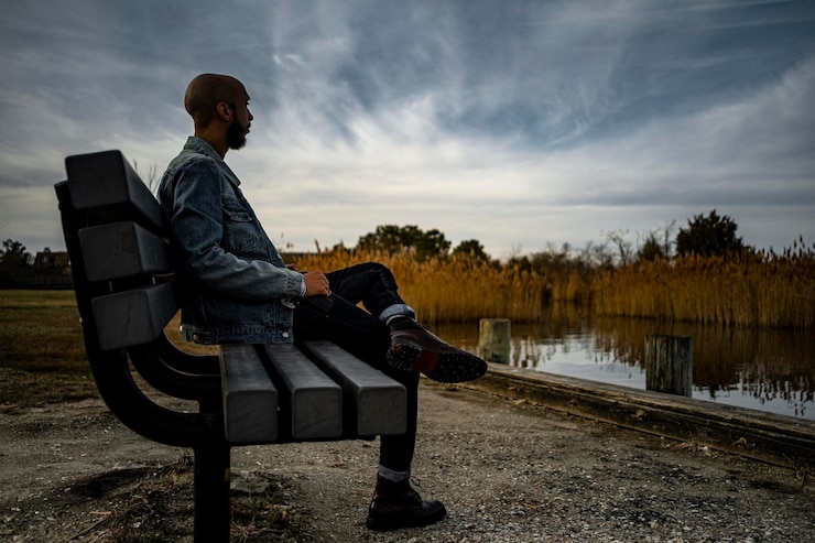 Photo vue latérale d'un jeune homme regardant le lac contre le ciel