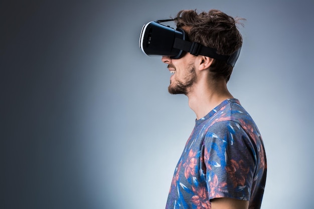 Vue latérale d'un jeune homme utilisant un casque vr émotions